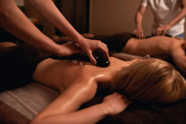 Os massagistas põem pedras da massagem traseira de clientes — Fotografia de Stock