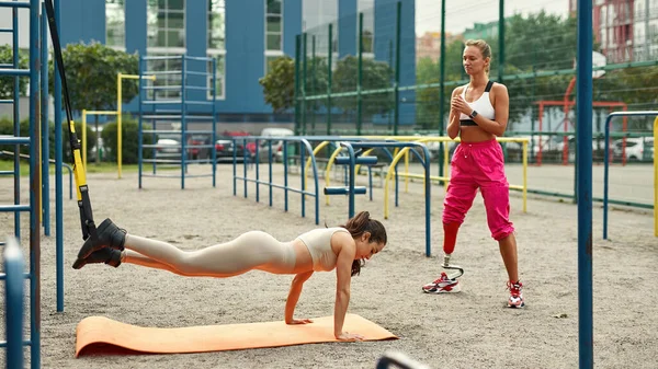 Chica discapacitada y su novia haciendo ejercicio — Foto de Stock