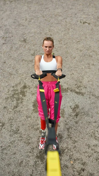 Disabled sports girl do exercise with trx belt
