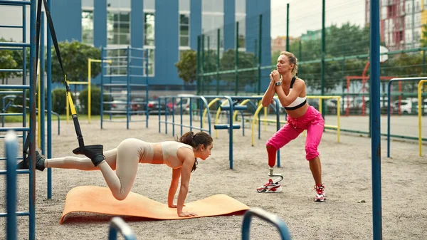 Mujer con pierna artificial y amigo hacer ejercicio — Foto de Stock
