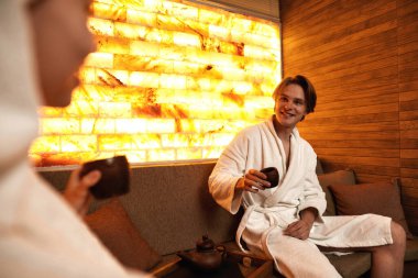 Genç, rahatlatıcı bir çift spa salonunda çay içiyor.