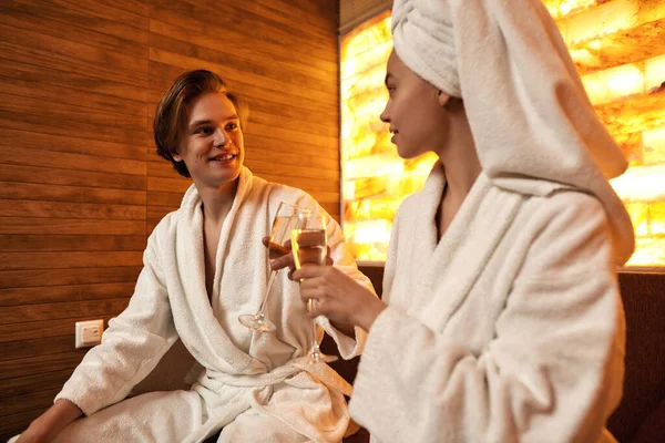 Casal brinde e beba champanhe no salão de spa — Fotografia de Stock