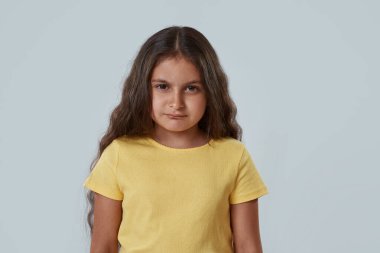Şüpheci suratlı küçük kız kameraya bakıyor.