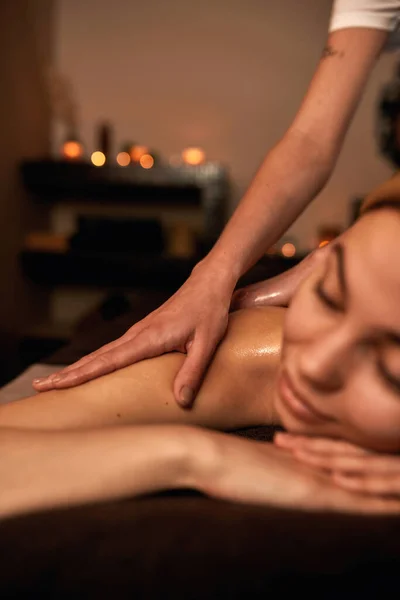 Masseur fazer massagem nas costas de mulher de descanso no salão de spa — Fotografia de Stock