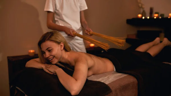 Masseur fazer massagem nas costas de relaxar menina com paus — Fotografia de Stock