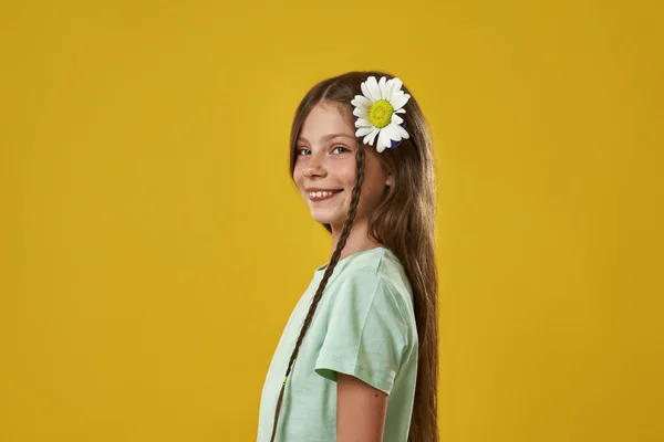 Vista lateral de chica con flor de manzanilla en el pelo —  Fotos de Stock