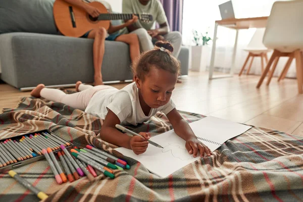 Flicka titta på rita och pappa med son spela på gitarr — Stockfoto