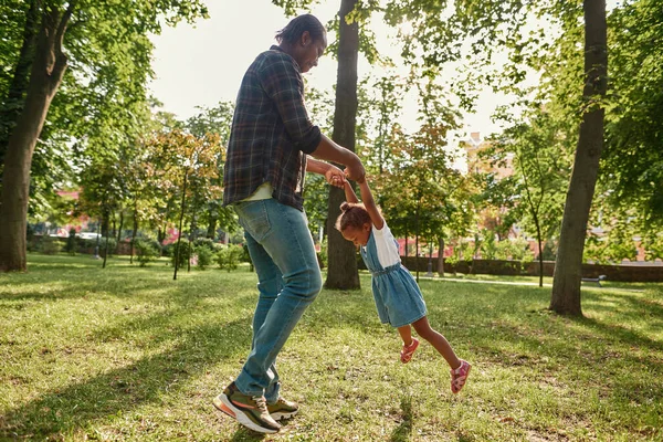 Fekete apa tartsa és spin lánya gyepen a parkban — Stock Fotó