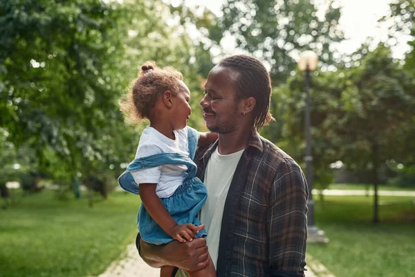 공원에서 딸을 품에 안고 있는 흑인 아버지 — 스톡 사진