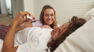 Kızın ellerinde hamilelik testine bakan bir adam.