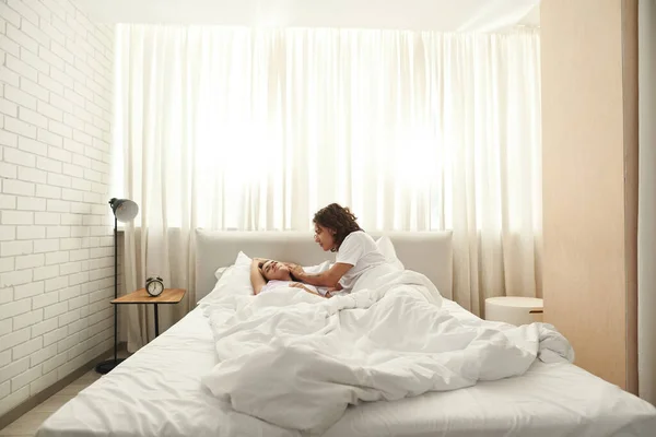 Man caressing sleeping girl on bed in morning — Stock Photo, Image