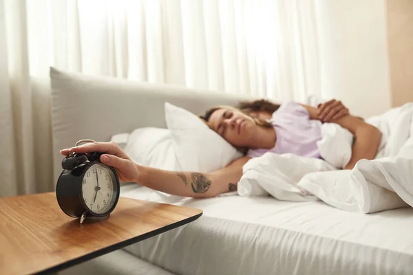 Vrouw stoppen wekker in de ochtend in de buurt vriendje — Stockfoto