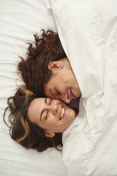 Têtes de couple avec les yeux fermés sous couverture sur le lit — Photo