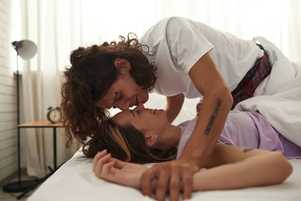 Young happy couple enjoying time together on bed — Photo