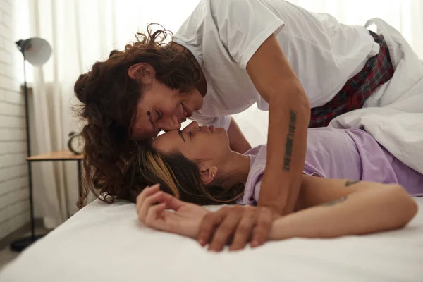 Tineri cuplu atingându-se unul pe altul în pat la domiciliu — Fotografie, imagine de stoc
