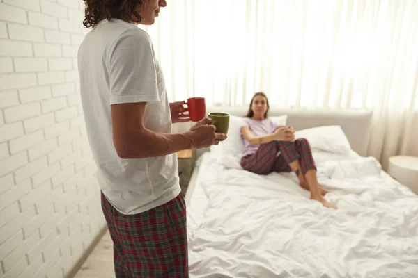 Man carrying tea or coffee to girlfriend on bed — Foto Stock