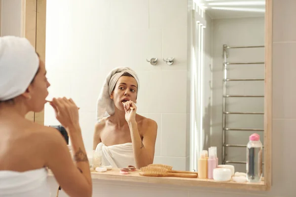 Mujer cepillando dientes con cepillo de dientes en el baño — Foto de Stock