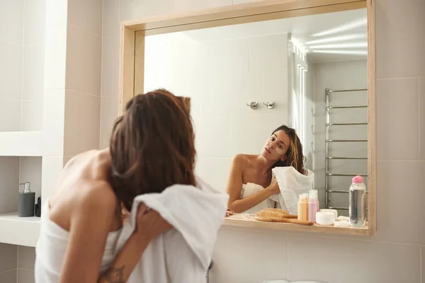 Mujer joven limpiándose el pelo con toalla en el baño — Foto de Stock