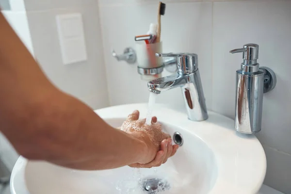 Adam ellerini lavaboda suyla yıkıyor. — Stok fotoğraf