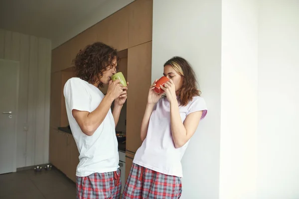 Guy and girl drink tea or coffee from cups at home — Foto Stock