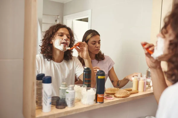 Girl take or put cosmetic cream while guy shaving — Foto de Stock