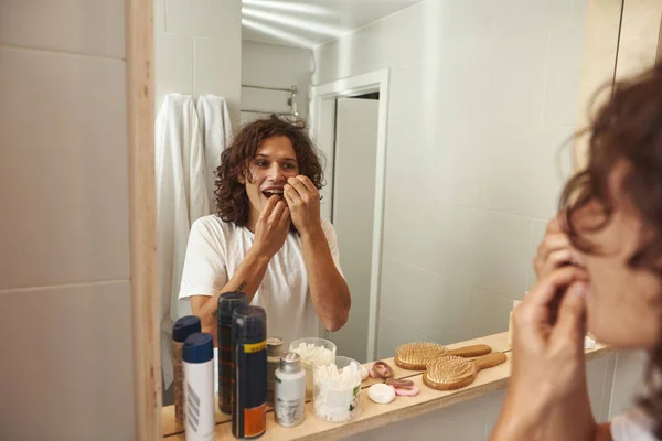 Joven caucásico hombre cepillo de dientes con hilo dental — Foto de Stock