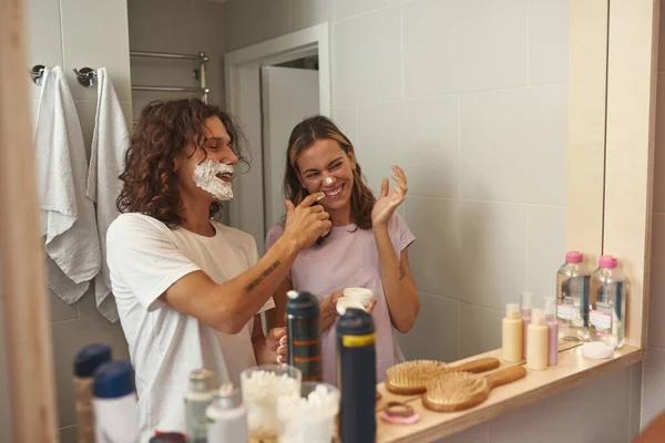 Man smearing foam on girlfriend nose while shaving — Foto de Stock