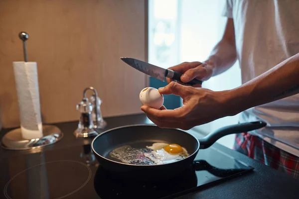 Man bryter ägg på pan under matlagning frukost — Stockfoto