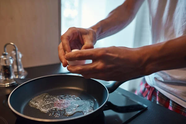 Man bryta och kasta ägg på pan med smör smältande — Stockfoto