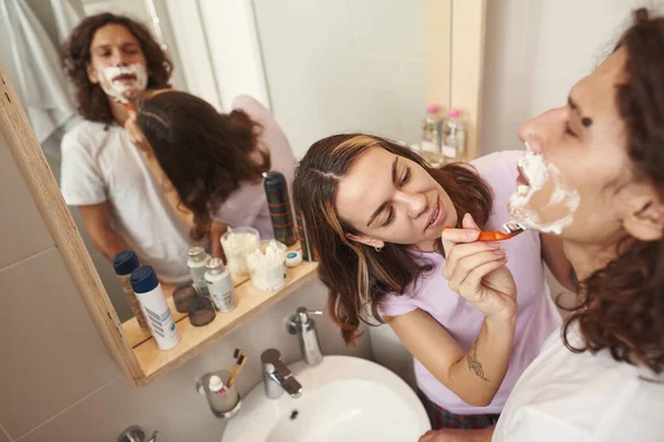 High angle view of girl shaving her boyfriend face — Fotografia de Stock