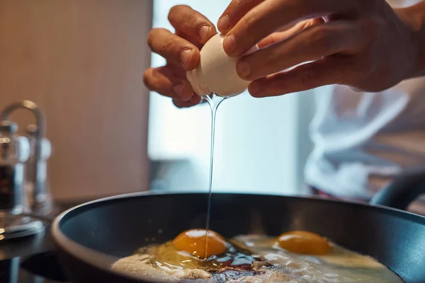 Vágott kép az emberről, ahogy törött tojást dobál a serpenyőre — Stock Fotó