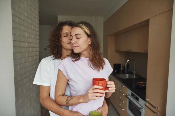 Man knuffel vriendin terwijl ze thee of koffie drinken — Stockfoto