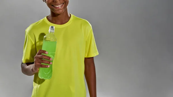 スポーツドリンクを持っている黒の少年の笑顔の一部 — ストック写真