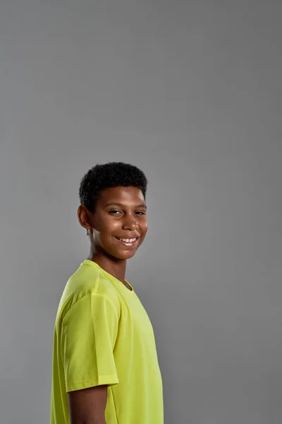 Side view of smiling black boy looking at camera — Fotografia de Stock