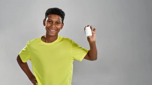 Black boy with hand on hip showing medical pills — Fotografia de Stock