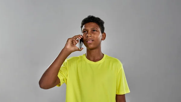 Продуманий спортивний чорний хлопчик говорить на смартфоні — стокове фото