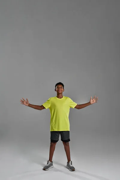 Pleased black boy with open arms looking at camera — Fotografia de Stock