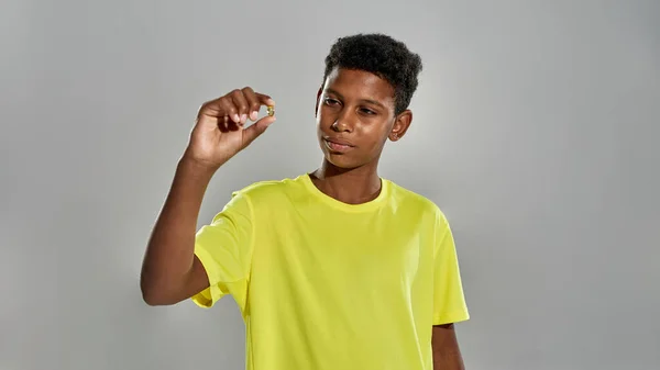 Black boy holding and looking at medical pill — Fotografia de Stock