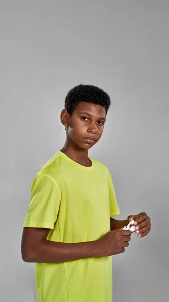 Black boy taking wireless earphones from package — Stock Photo, Image