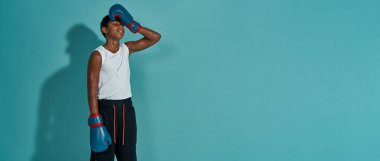 Yorgun siyah çocuk boksör alnına dokunuyor.