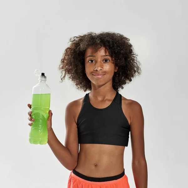 Fekete lány sport ital nézi kamera — Stock Fotó
