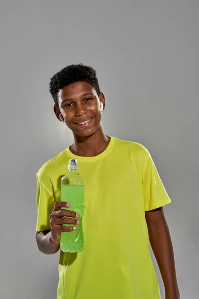 Spor içeceği şişesi olan atletik zenci çocuk. — Stok fotoğraf