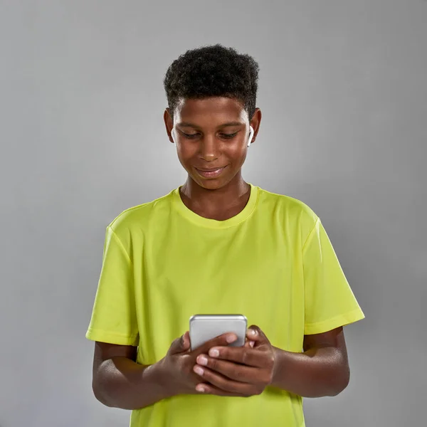 Front view of smiling black boy browse smartphone —  Fotos de Stock