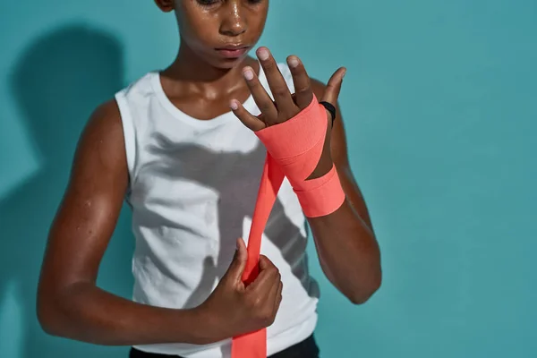 Black boy boxer wrapping boxing bandage on hand — Foto Stock