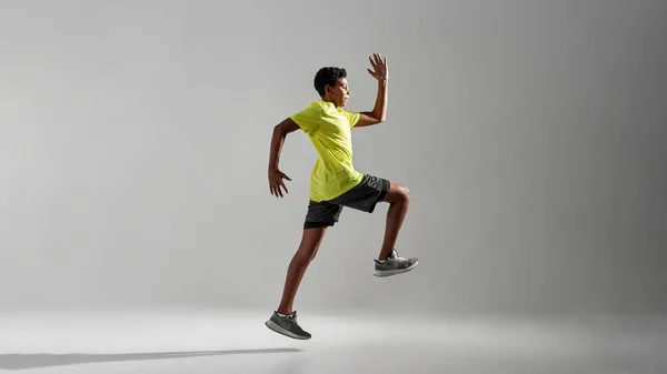 運動黒の少年ジョギングやランニングの側面図 — ストック写真
