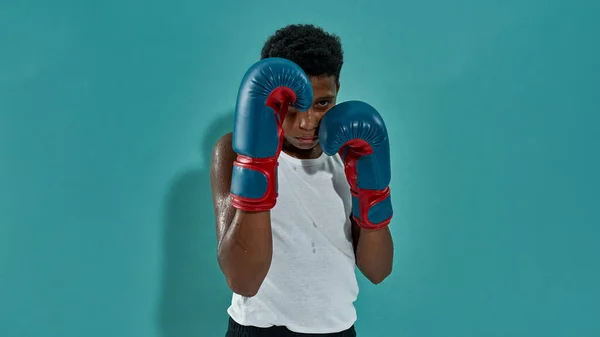 Framifrån av självsäker svart pojke boxare boxning — Stockfoto