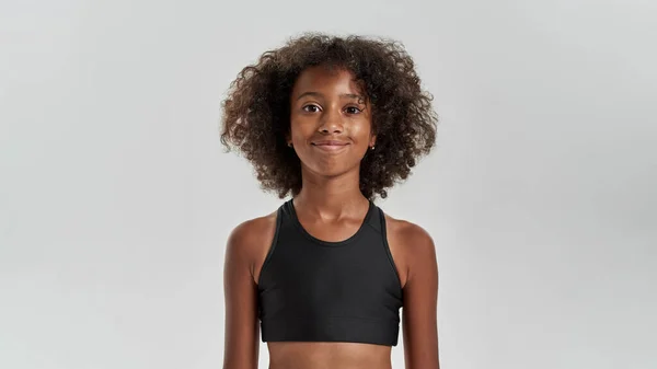 Zugeschnittenes Bild eines lächelnden schwarzen Mädchens, das in die Kamera schaut — Stockfoto