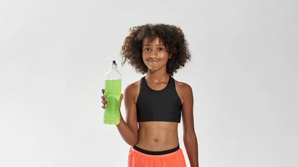 Sportliches schwarzes Mädchen mit einer Flasche Sportgetränk — Stockfoto