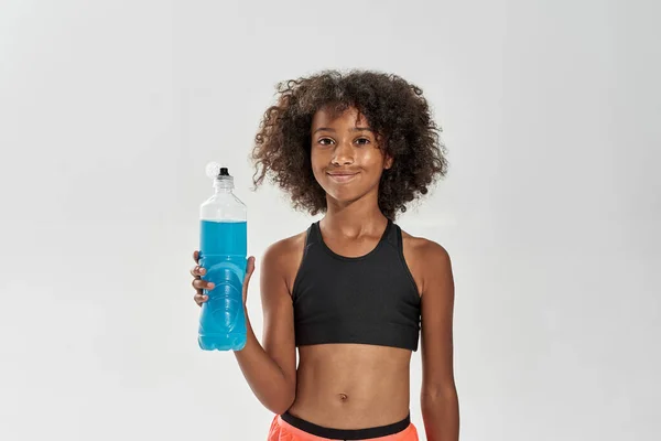 Fekete lány hold nyitott üveg kék sport ital — Stock Fotó