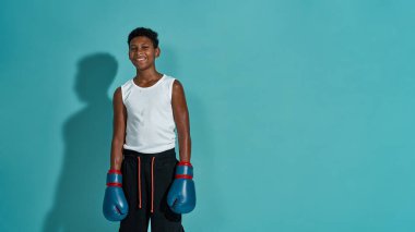 Gülümseyen siyah çocuk boksör kameraya bakıyor.